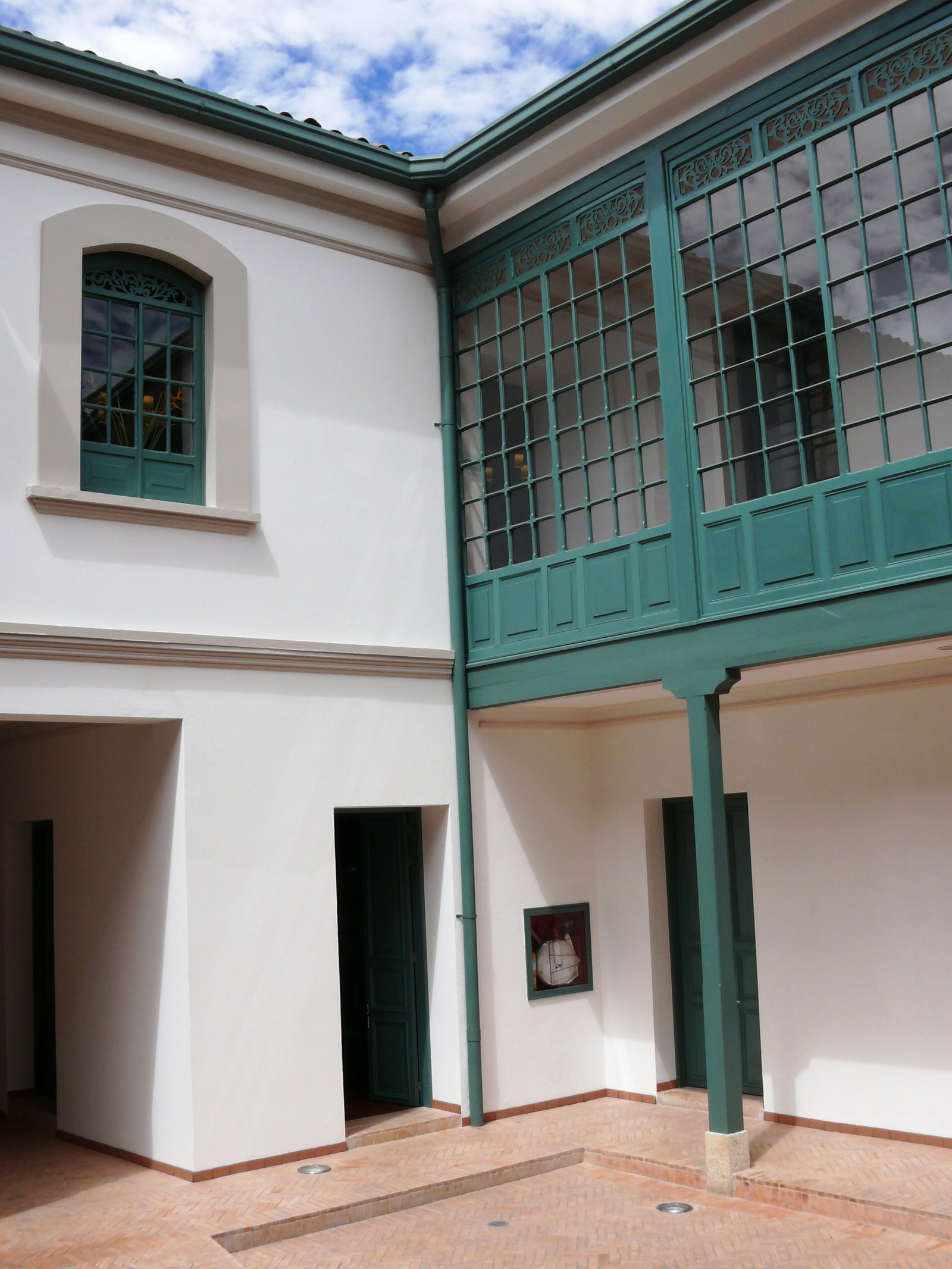 Carpinterías y mamparas verdes alrededor del patio restaurado